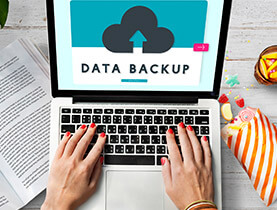 手塗紅色指甲油的女性使用筆記型電腦的特寫