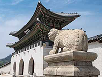 藍天白雲與韓國首都首爾的景福宮,前景為守護神石獅子。